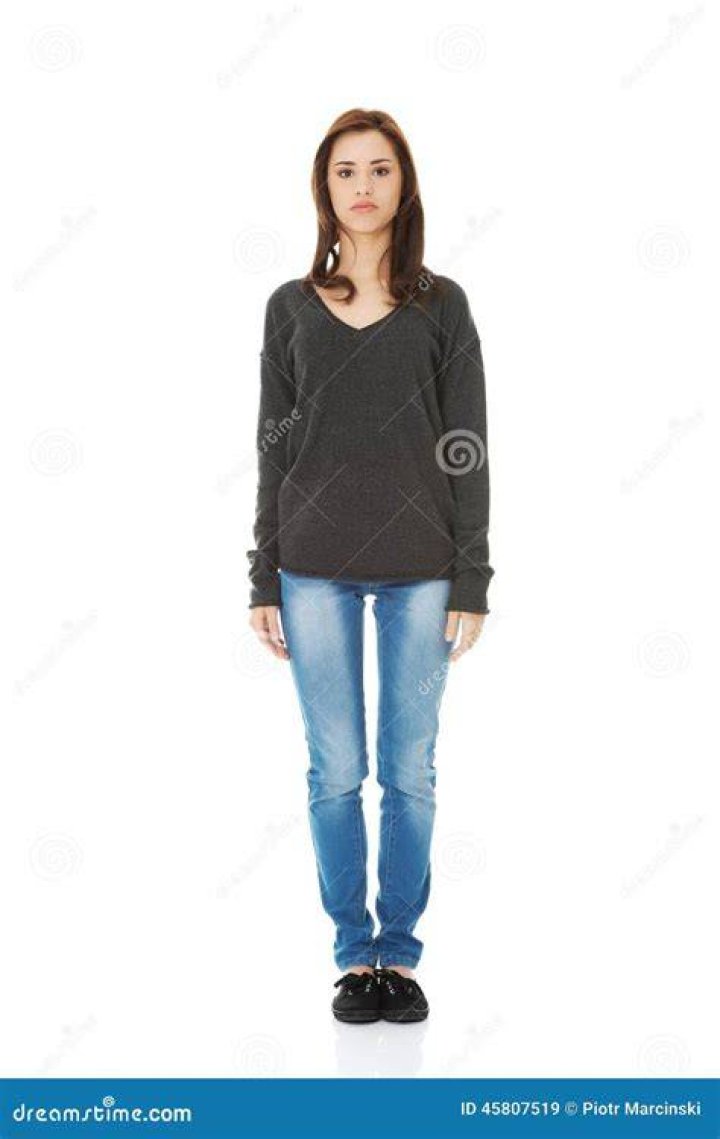 a woman standing in front of a wall with boxes on it a woman standing in front of a wall with boxes on it